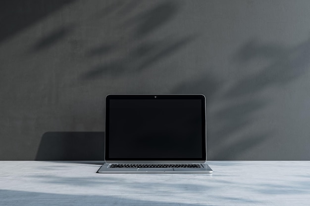 Close up of laptop with empty screen and mock up place at concrete workplace with shadows 3D Rendering