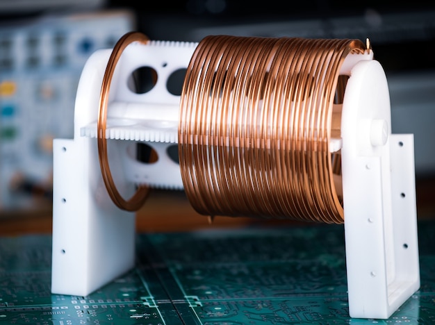 Close-up large and small coils with copper wire stand on a green microcircuit at a factory of classified military equipment. Super secret high-frequency components and equipment concept