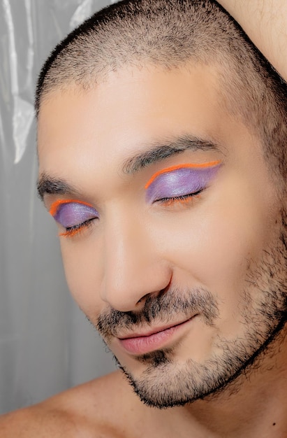 Close up of latin man with purple and orange eyeliner