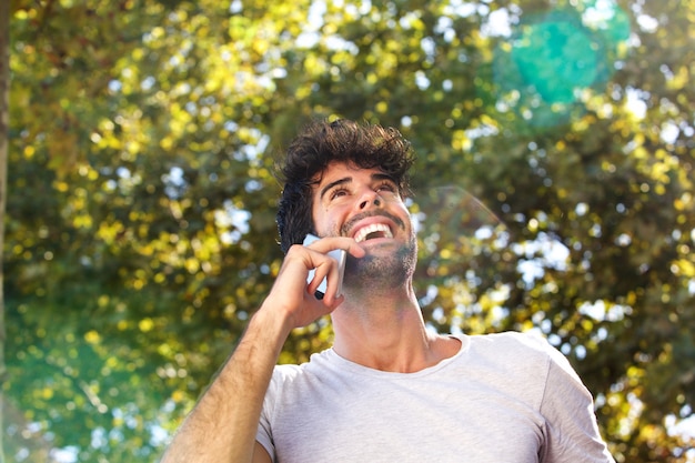 Close up laughing man talking on mobile phone outside in autumn