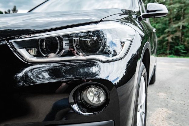 Close up of the LED headlights detail on black modern car.