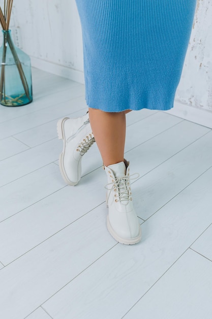 Close up of legs in stylish white shoes Collection of women's shoes made of natural leather Women's winter boots