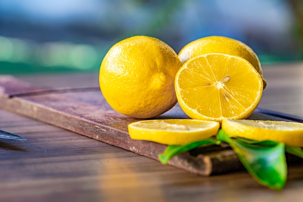 Close up of lemon and green leaves on rustic wooden table