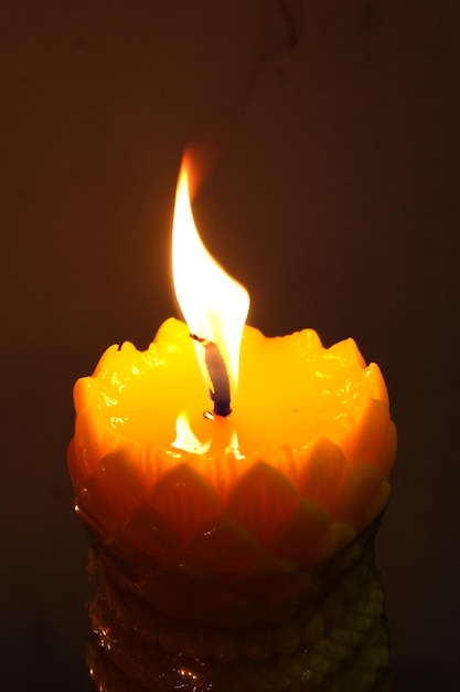 Photo close-up of lit candle against black background