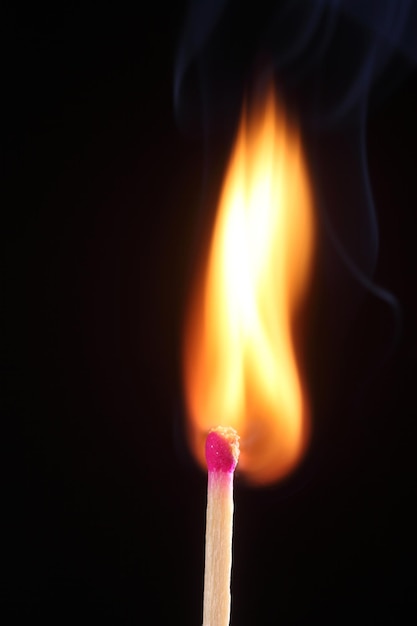 Photo close-up of lit candle against black background