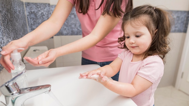 Close-up little girl washing hands