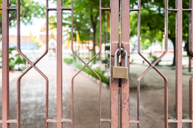 Close up to the lock hangs on to brown steel door at outdoor field