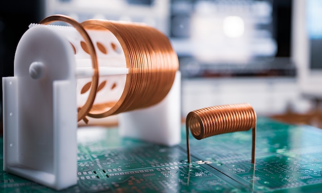 Close-up A lot of skeins of twisted copper wire are standing on a green microcircuit. Factory concept for the production of powerful oscillatory circuit and high-frequency components