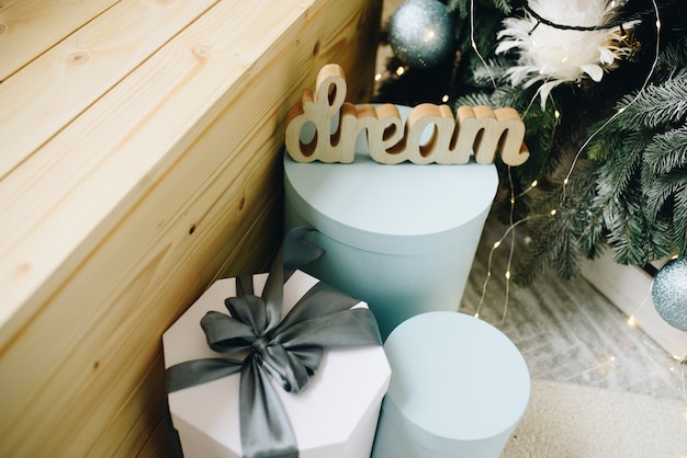 Close up of lovely packed Christmas Gifts next to decorated Christmas Tree