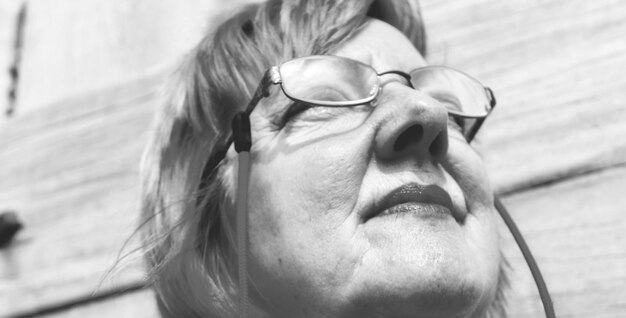 Photo close-up low angle view of mature woman wearing eyeglasses while looking away