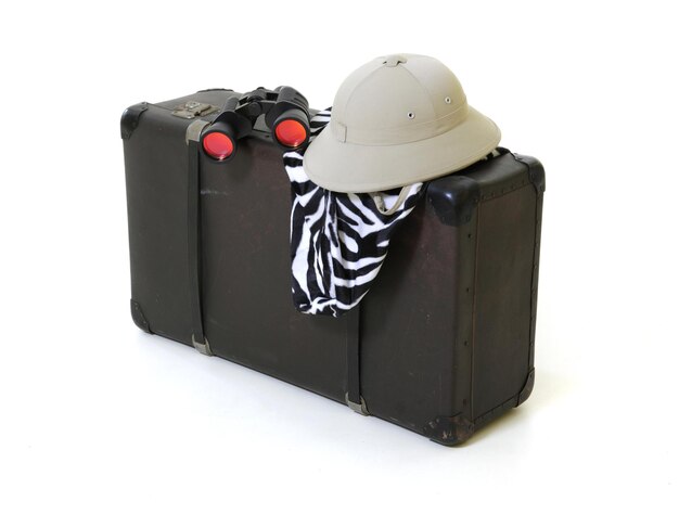 Photo close-up of luggage with hat and binoculars against white background