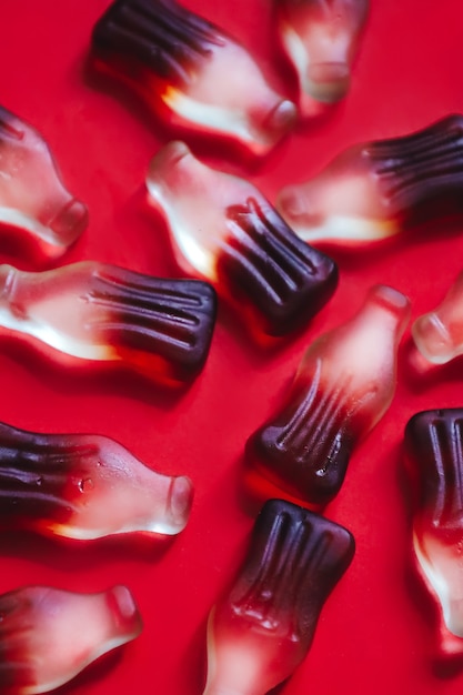 Close up macro jelly gummy candies in bottles shape with cola drink flavour