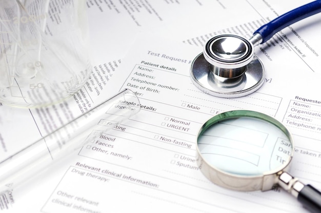 Photo close-up of magnifying glass and stethoscope on papers