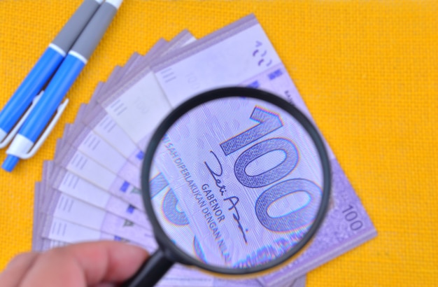 Close Up of Malaysia Bank Notes With Magnifying Glass, Finance Concept Selective Focus