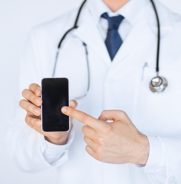 close up of male doctor pointing at smartphone