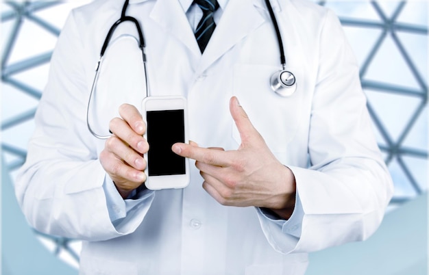 Close-up of male Doctor pointing at smartphone