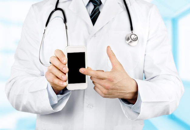 Close-up of male Doctor pointing at smartphone