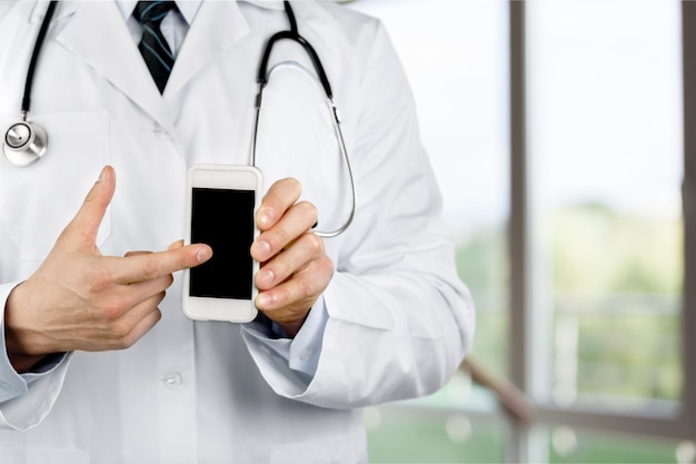 Close-up of male Doctor pointing at smartphone