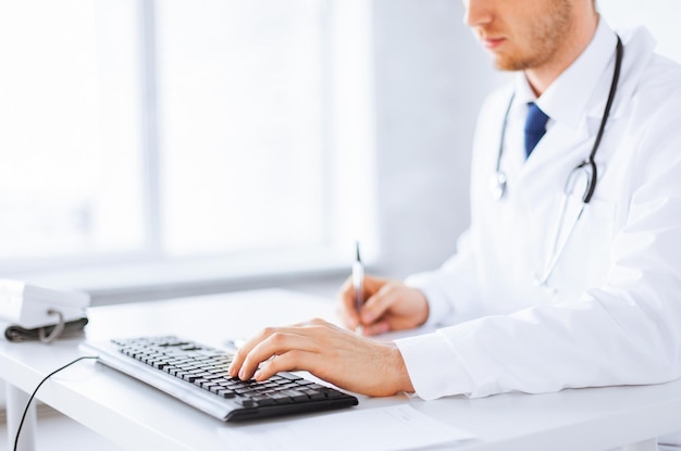 close up of male doctor typing  on the keyboard