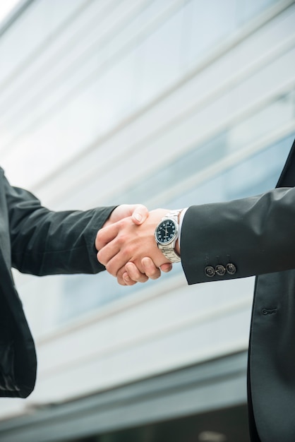 Close-up of male and female shaking hands on business deal