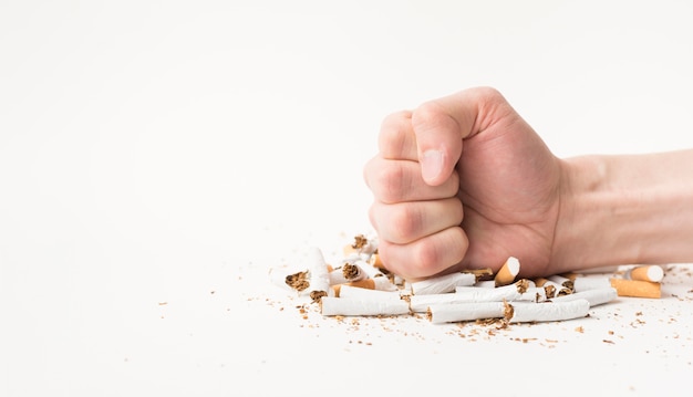 Close-up of male hand breaking cigarettes with his fist