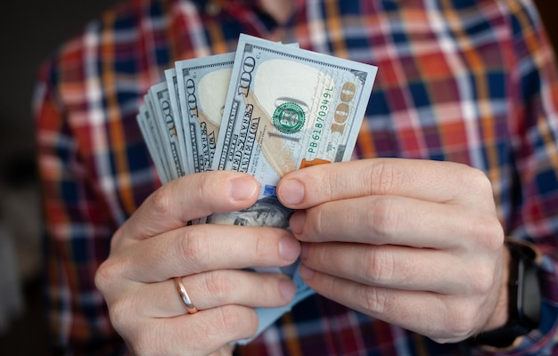 Close up male hand Counting and holding money us dollar.The concept of financial business and crisis