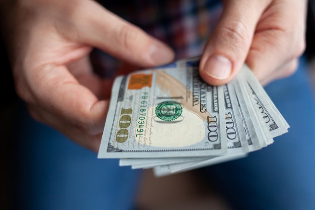 Close up male hand Counting and holding money us dollar.The concept of financial business and crisis