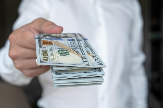 Close up male hand counting and holding money us dollar