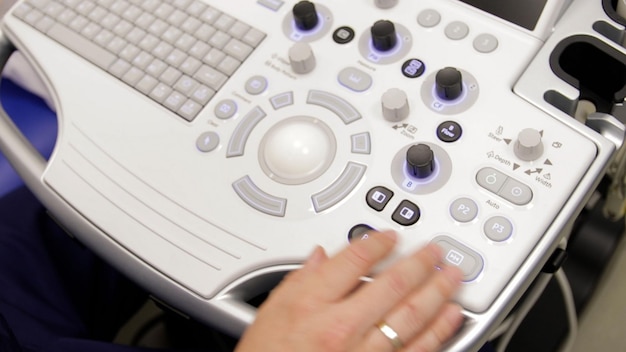 Photo close up of male hand operating ultrasound machine