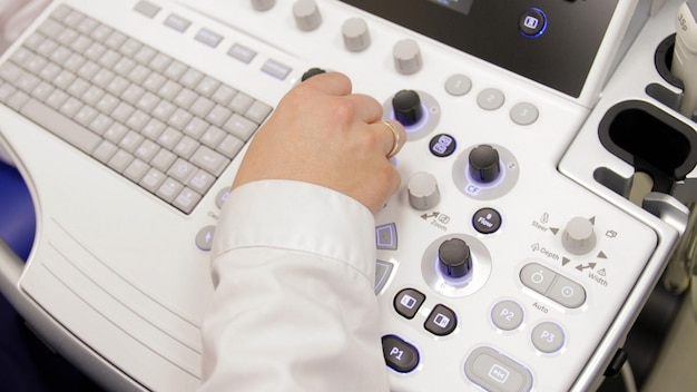 Photo close up of male hand operating ultrasound machine