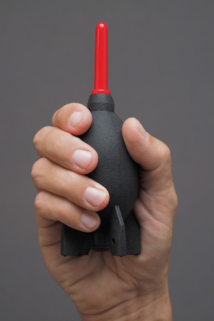 Close up of male hand sweeping dust using air blower