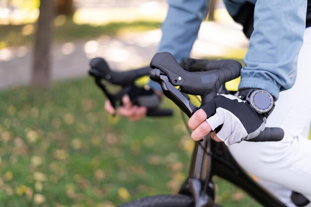 Close-up of male hands hold the handlebars of a bicycle while riding.