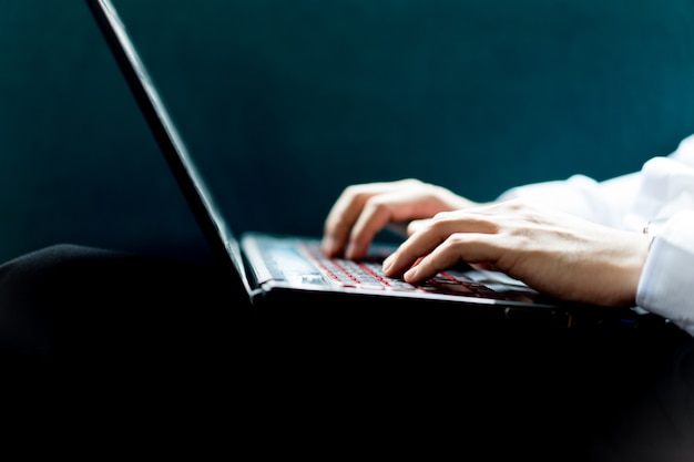 Close up of male hands with laptop computer typing on keyboard