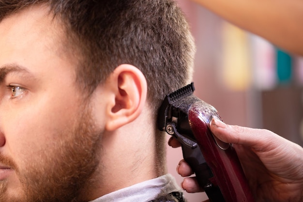 Close up of a male student having a haircut with hair clippers