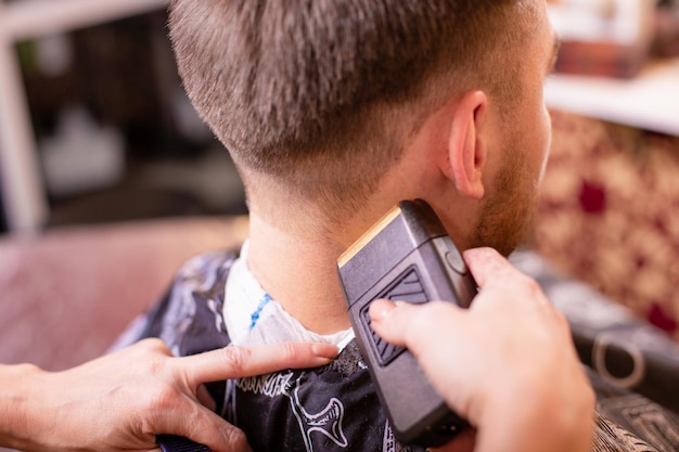 Close up of a male student having a haircut with hair clippers