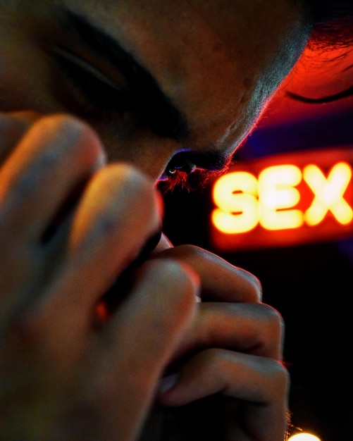 Photo close-up of man against illuminated sex text