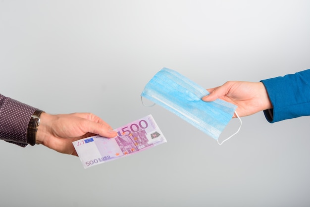 Close- up of a man buying a medical mask. The concept of high demand. Selling blue medical masks for dollars.