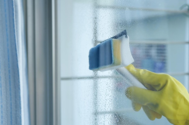 Close up of man hand cleaning window glass