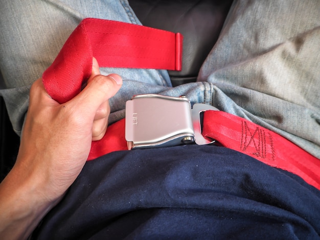 Close up of man hand seat belts on airplane seat.