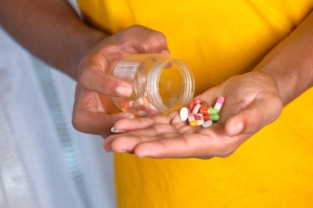 Close up of man hand taking medicine .