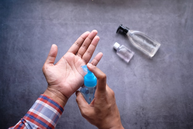 Close up of man hand using sanitizer gel isolated on black