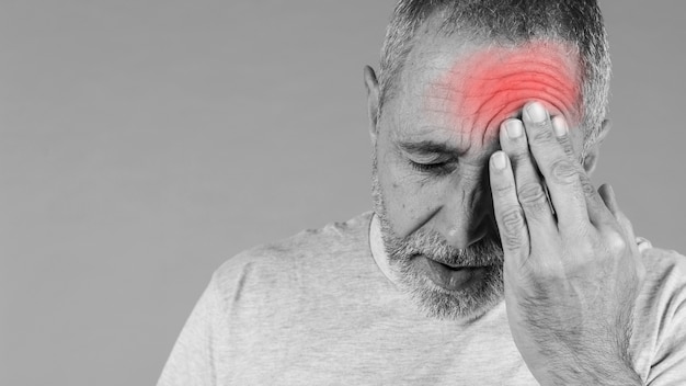 Close-up of a man holding his head in pain