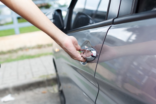 Close up of a man opens car's door.