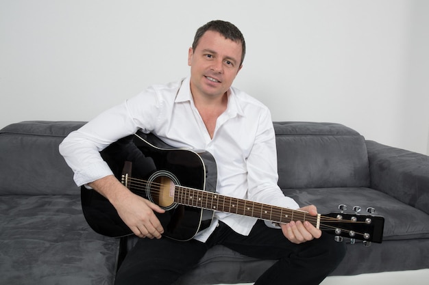 Close up on a man playing guitar at home