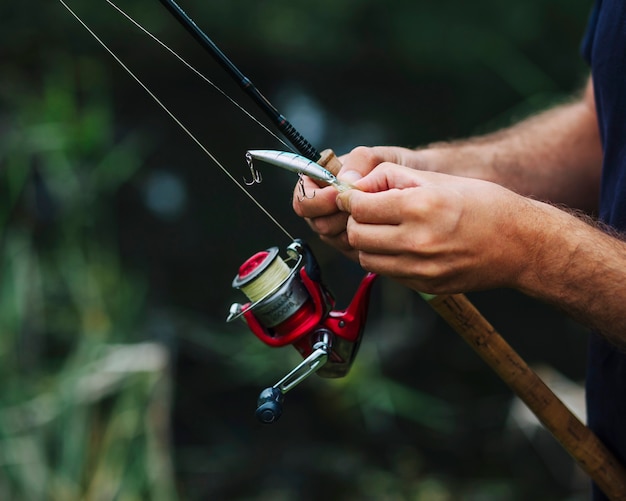 Close-up of man's hand tying fishing hook