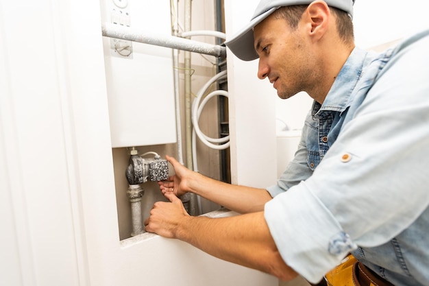 Close-up Of Man's Hands Turning The Knob Of Electric Boiler