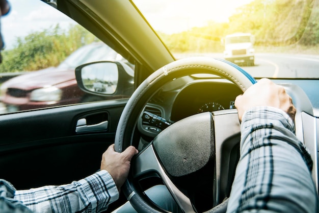 Photo close up of man's hands on the wheel a person driving with hands on the wheel a man with hands on the wheel of the car concept of hands on the wheel of a car