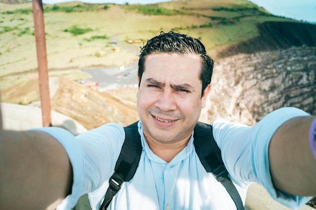 Close up of man taking an adventure selfie Tourist taking a selfie at a viewpoint Adventurous people taking a selfie at a viewpoint Handsome tourist taking a selfie on vacation