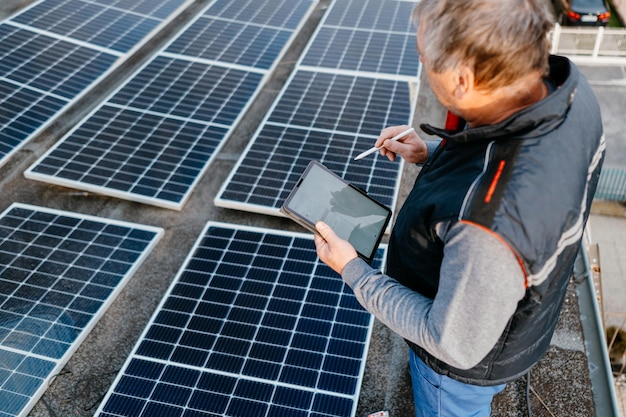 Close up of man technician using application checking solar panel setup high quality photo