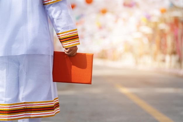 Close up man university graduates in graduation gown with diploma